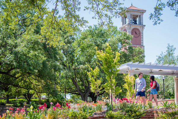 Students walking on campus in front of Moulton Tower.