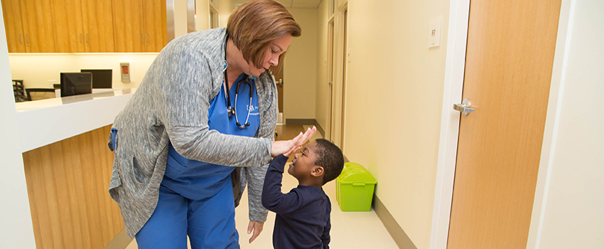 Nurse high fiving a little boy