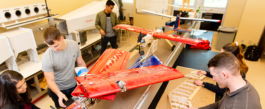 Mechanical Engineering students working on plane.