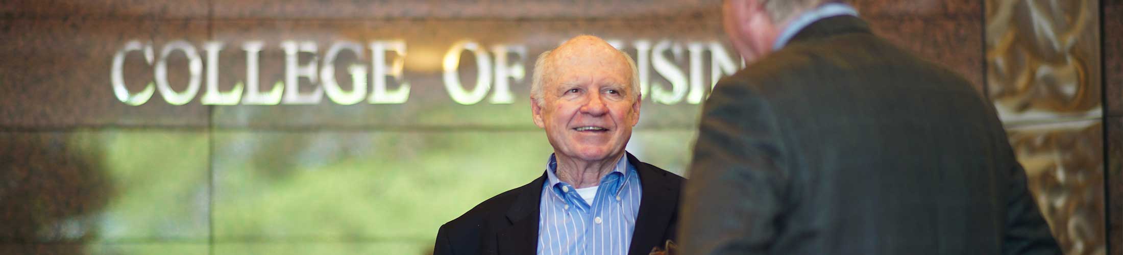 Professor smiling outside of Mitchell College of Business