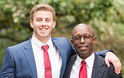 Professor and male student with arm around each