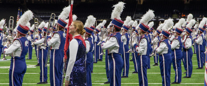 Band and color guard performing at game.