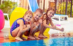 Three kids at swim party by pool.